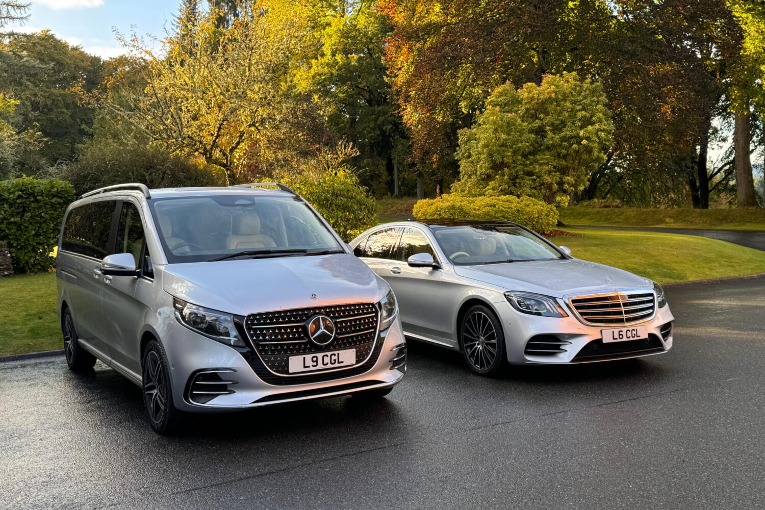 2 silver vehicles in front of trees
